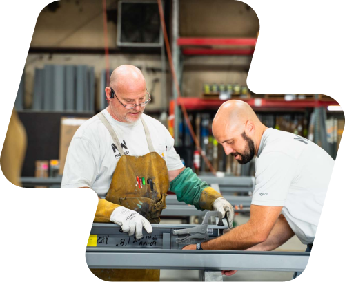 Two Midwest Door shop hands fabricating a hollow metal frame at the bench