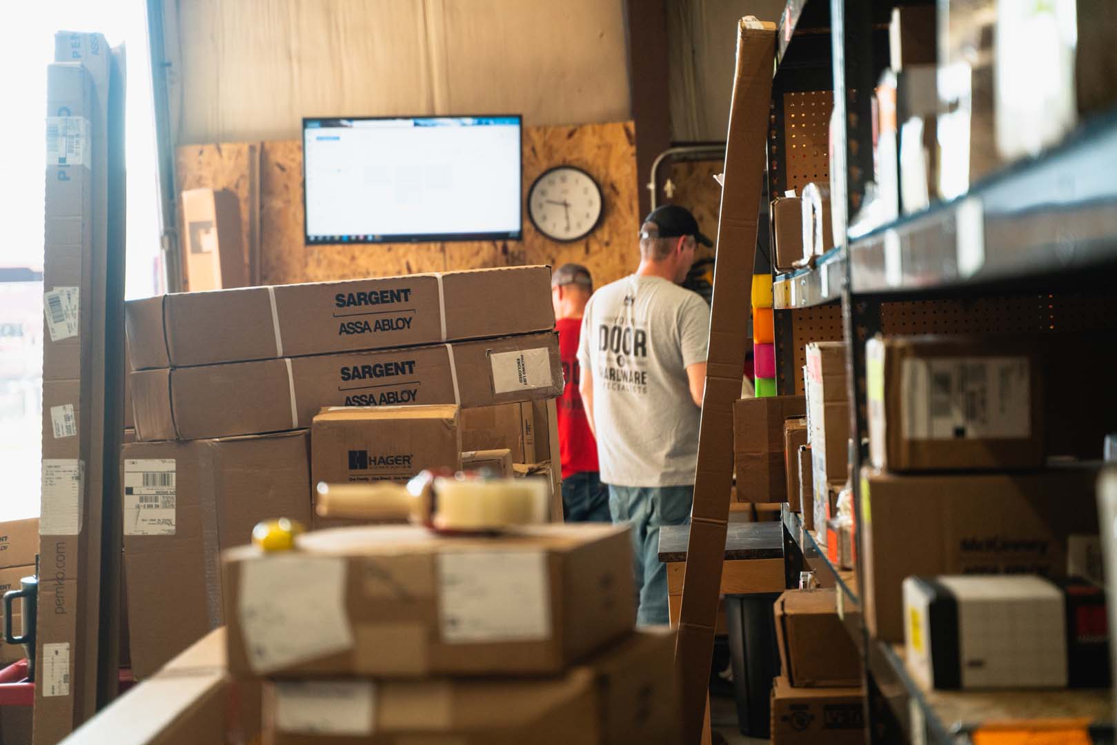 Hardware cartons on the warehouse shelves, staged by job